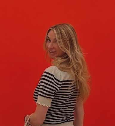Olena in front of a vivid red gallery wall